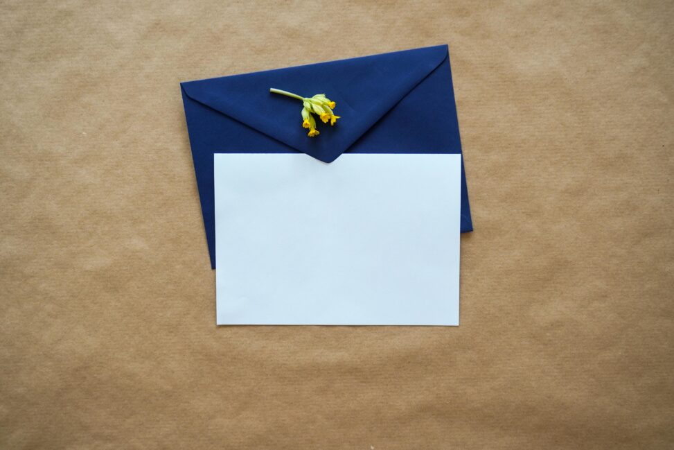 white invitation on top of a blue envelope